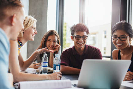 group chatting around an open laptop