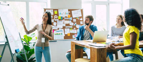 Group of professionals in a marketing meeting with a young woman presenting.