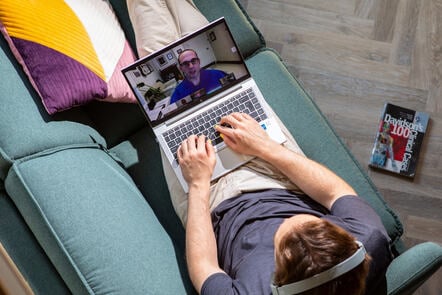 Person watching a Zoom lecture with a doctor on a laptop.