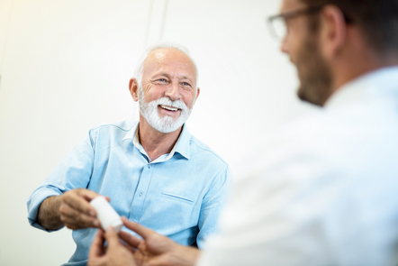 Happy senior man receiving a prescription medicine from doctor