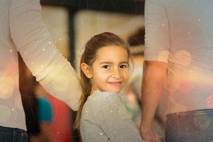 Smiling child holding hands with two protective adults