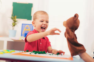 Boy interacting with puppet of a bear