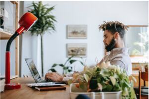 A man works on his laptop in his home