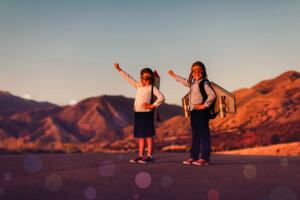 Two little kids with rocket backpacks and goggles, fists raised to the sky.