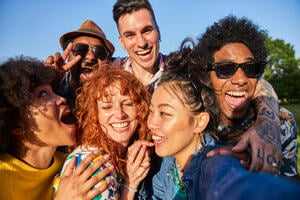 Friends in different ethnic group meeting up on a summers evening, having fun together.