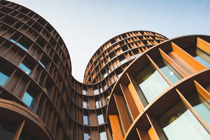 Image of large architectural building in metal and glass with curved features 