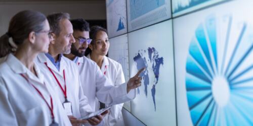 Healthcare workers looking at graphs on a screen